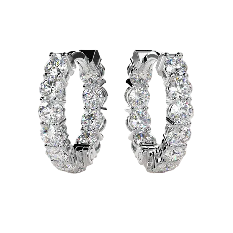 A pair of silver hoop earrings set with round brilliant-cut diamonds, shown against a solid light beige background.