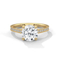 Gold ring with a large diamond and smaller diamonds on the band against a white background