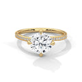 Gold ring with a large diamond and smaller diamonds on the band against a white background