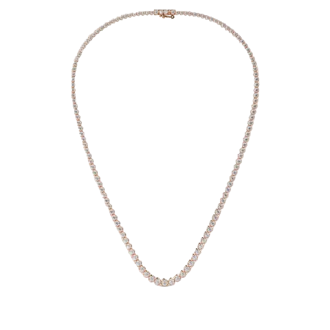 A delicate tennis-style necklace with small clear stones in a silver-toned setting, displayed on a plain warm beige background.