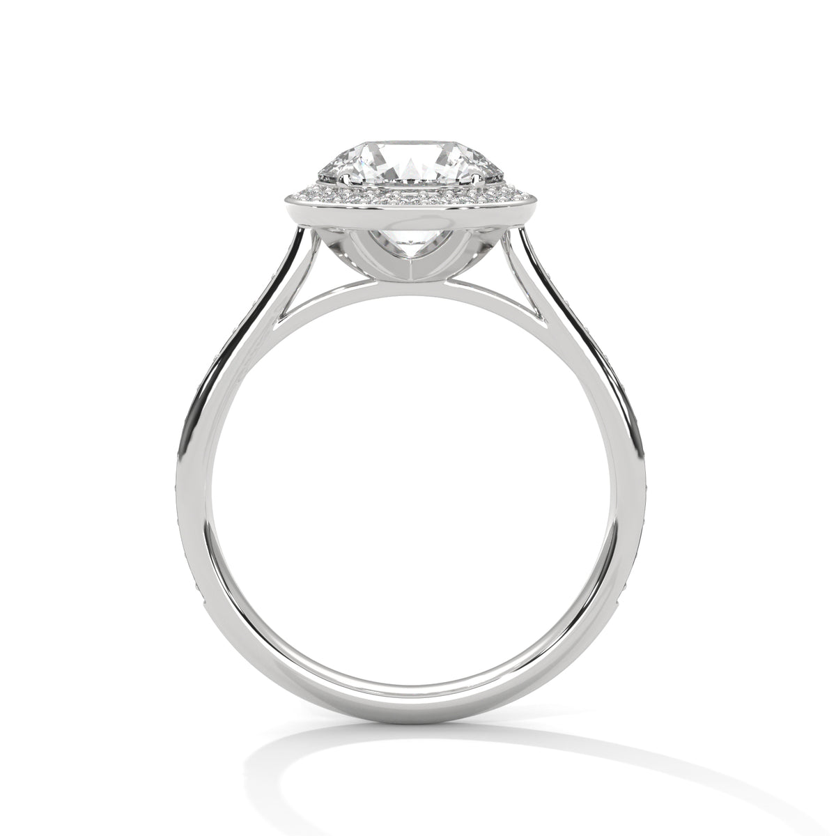 A silver-toned diamond ring with a round-cut center stone and a halo of smaller diamonds, shown from the front on a white background with a soft reflection below.