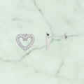 Heart-shaped earrings with clear stones on a white background