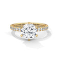 Gold ring with a large diamond and smaller diamonds on the band against a white background