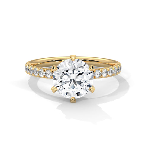 Gold ring with a large diamond and smaller diamonds on the band against a white background