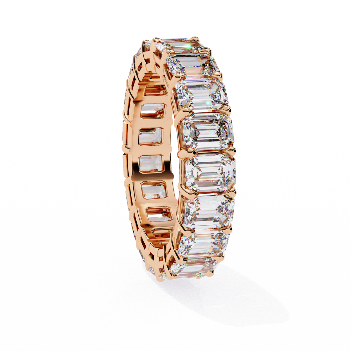 Rose gold ring with emerald-cut diamonds on a white background