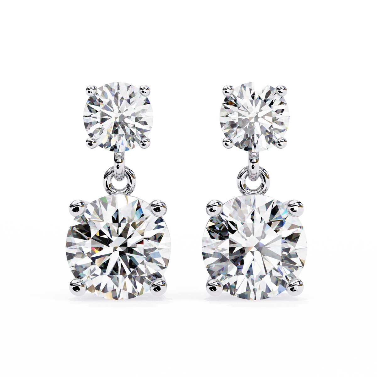 A pair of silver drop earrings featuring a small round-cut diamond at the top and a larger cushion-cut diamond at the bottom, set in polished silver on a white background.