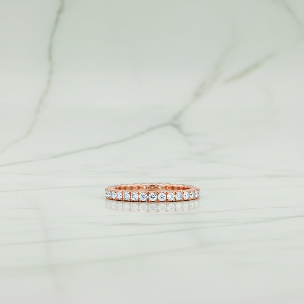 Rose gold ring with diamonds on a white background