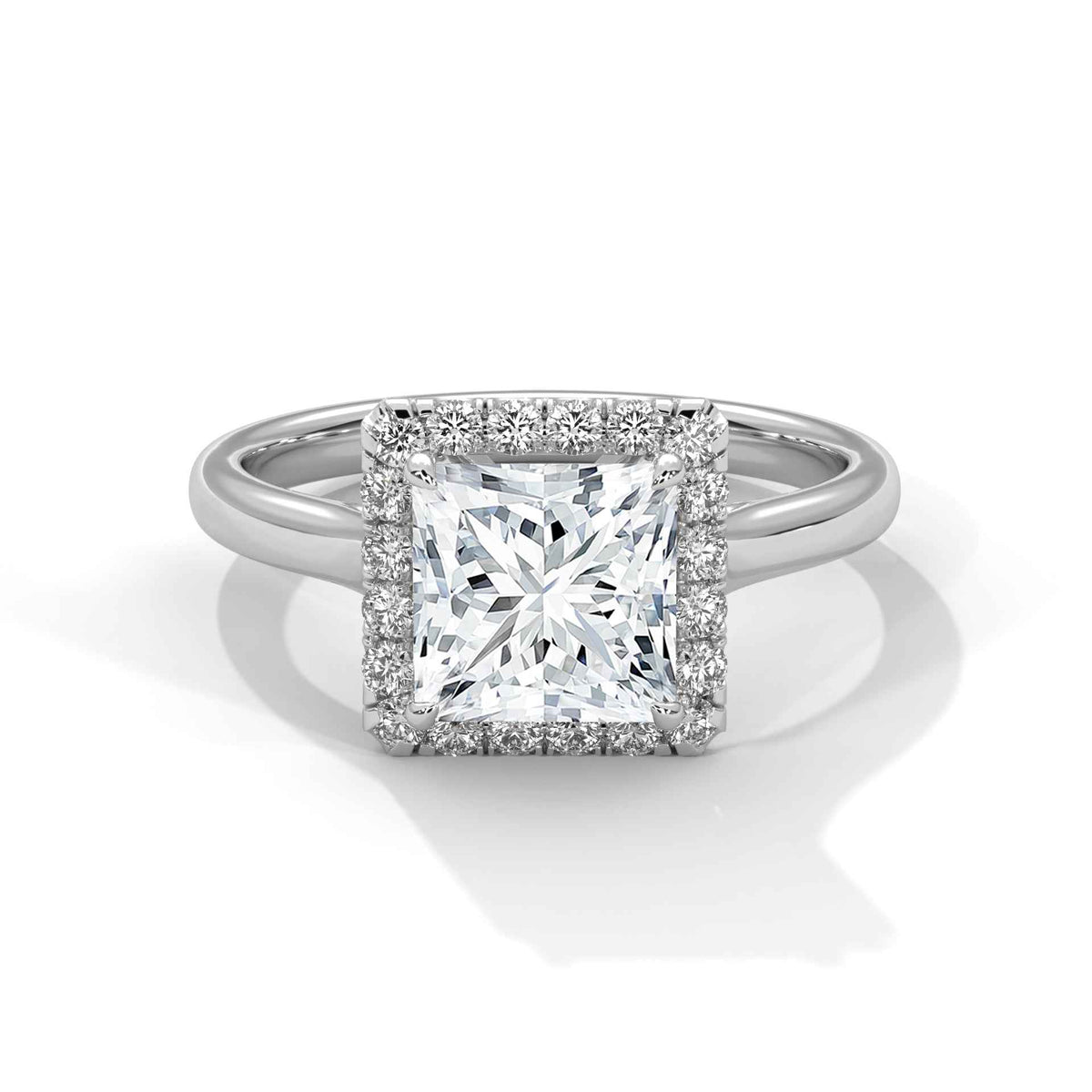 A radiant cut diamond halo ring in a polished silver-colored metal, featuring a prominent central diamond surrounded by a halo of smaller diamonds on a split shank band, set against a clean white background.