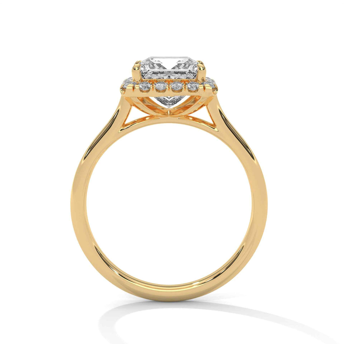 A yellow gold ring with a halo setting featuring a central clear rectangular gemstone and smaller side stones, shown on a clean white background.