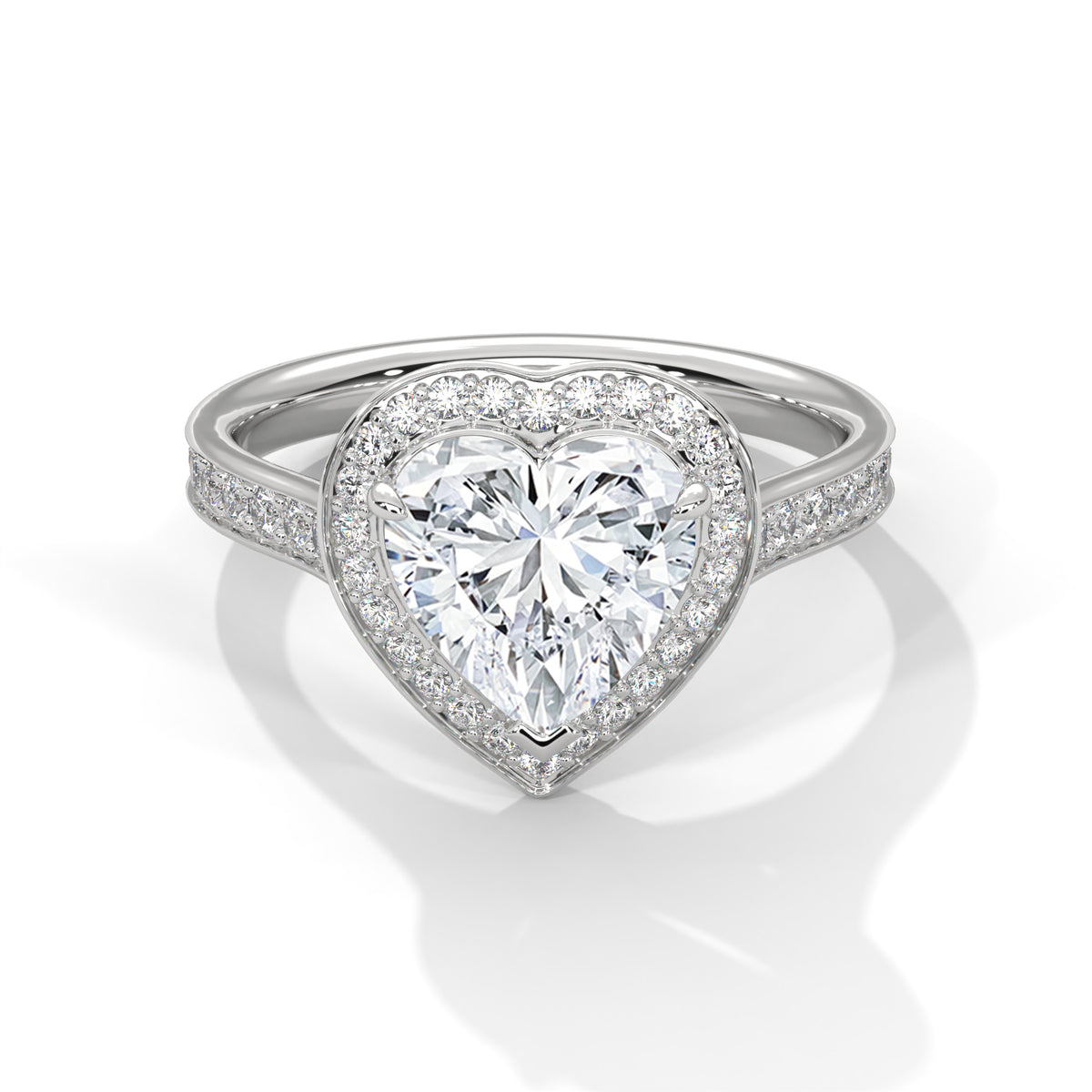 Heart-shaped diamond ring with a white gold band on a reflective surface.