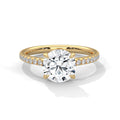 Gold ring with a large diamond and smaller diamonds on the band against a white background