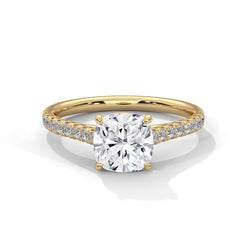 Gold ring with a large diamond and smaller diamonds on the band against a white background