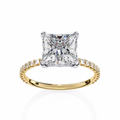 Gold ring with a large diamond and smaller diamonds on the band against a white background