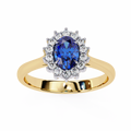 Gold ring with a blue gemstone and diamond halo on a white background