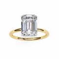 Gold ring with a large emerald-cut diamond on a white background