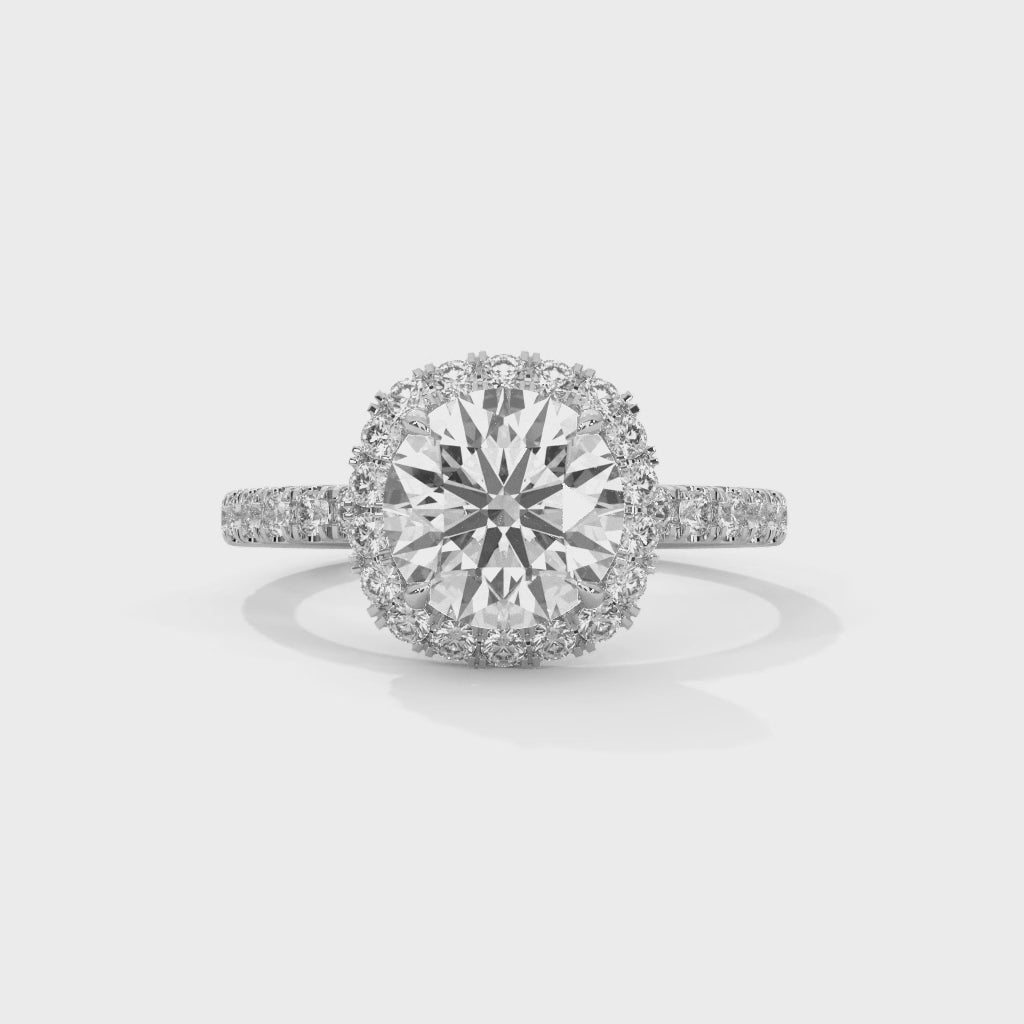 Anillo de diamantes de talla brillante redonda y perfil alto, con halo de cojín suave y brazo con pavé